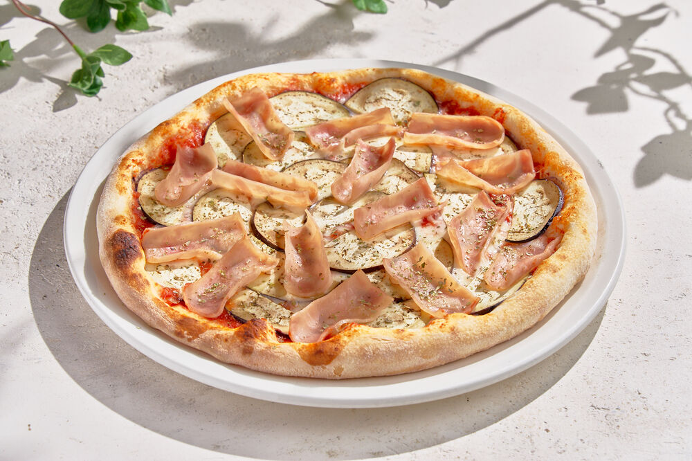 Pizza with eggplant, ham and Parmesan