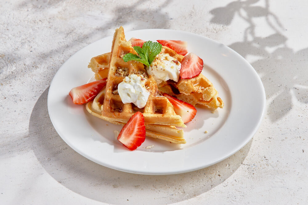 Belgian waffles with seasonal berries and orange sauce