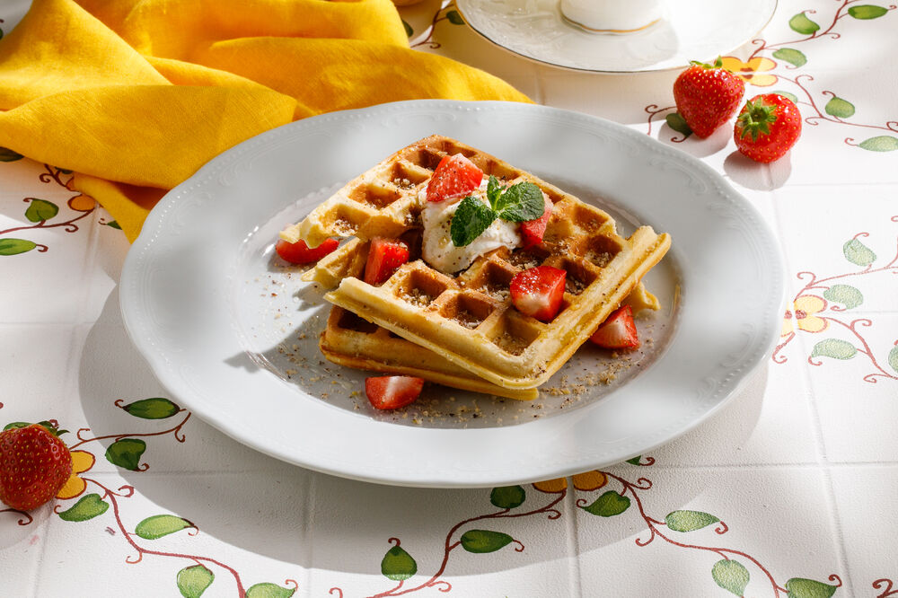 Belgian waffles with seasonal berries and orange sauce