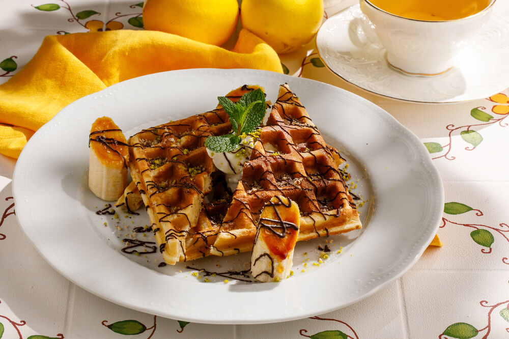Belgian waffles with banana, chocolate and pistachios