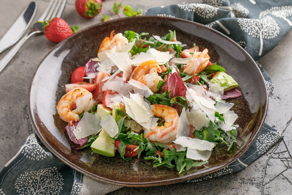 Rocket salad with shrimp, cherry tomatoes and strawberries