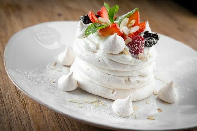 Meringue with butter cream and berry sauce