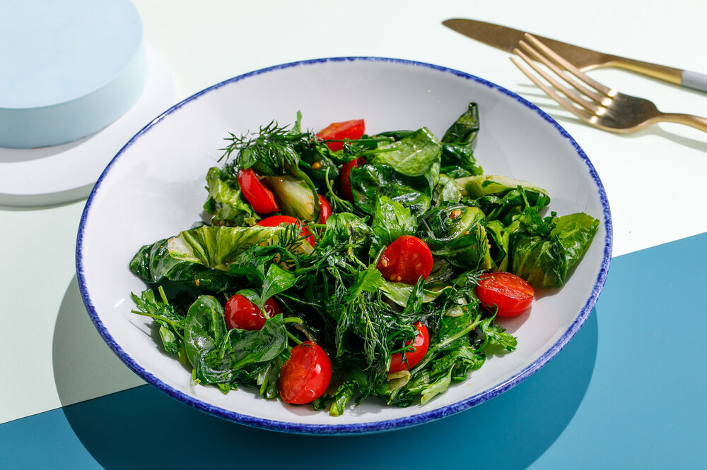 Fried fresh herbs with tomatoes