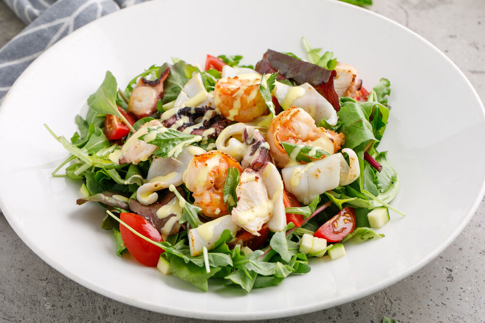 Salad with seafood and orange sauce