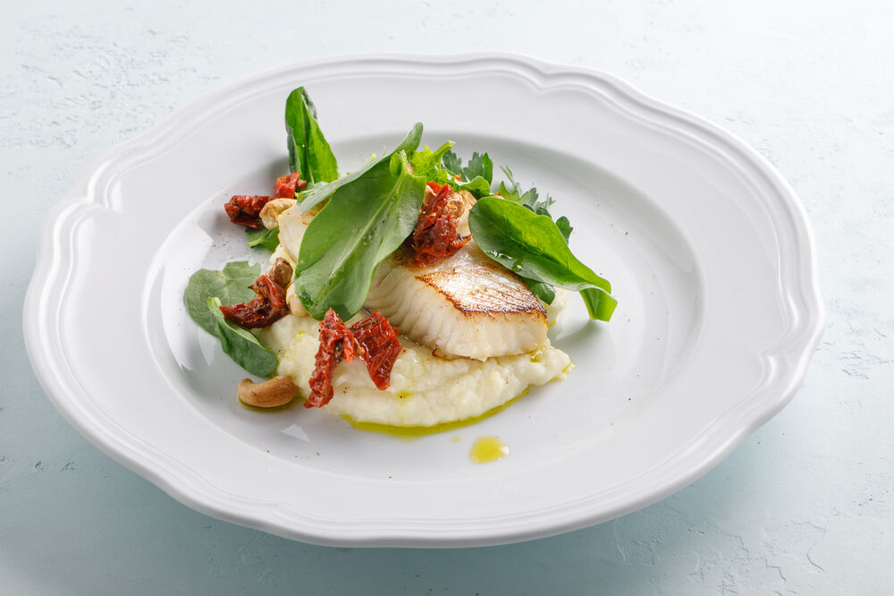 Halibut with mashed potatoes, cashews and dried tomatoes