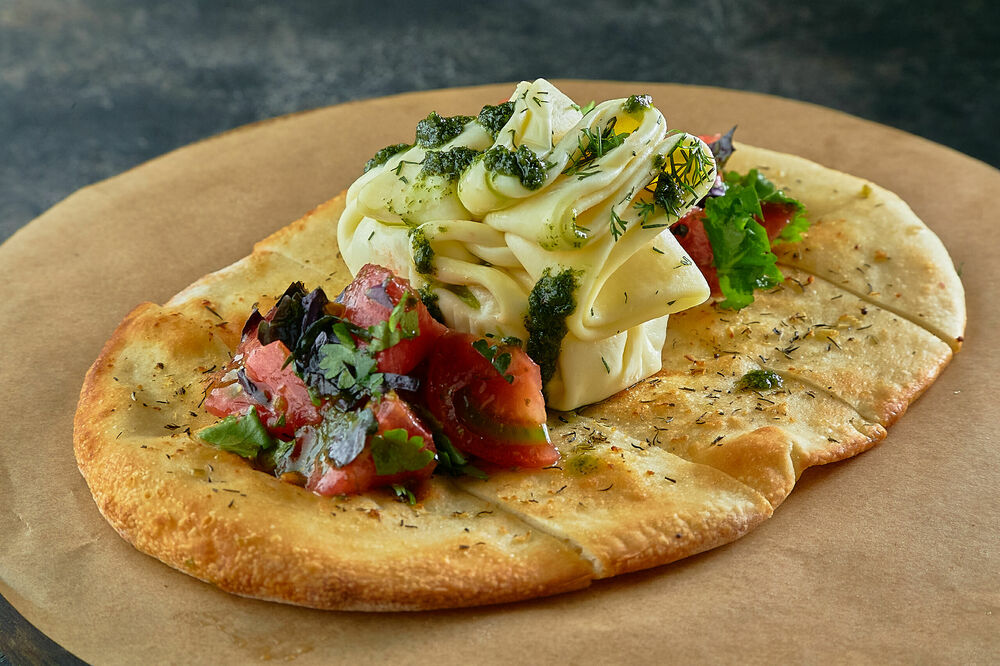 Farmer Nadugi with tomatoes on homemade flatbread