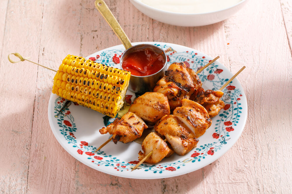 Kebab on a skewer with an ear of corn