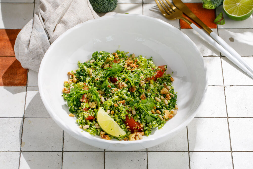 Avocado and tomato salad with chopped broccoli, herbs and nuts
