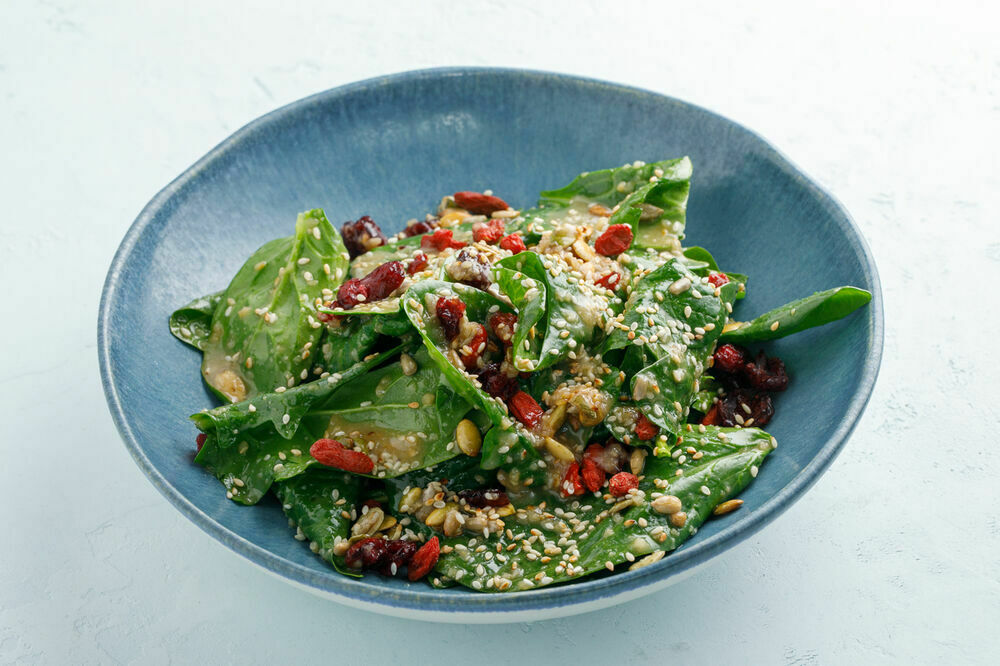 Salad with spinach, nuts sauce and goji berries