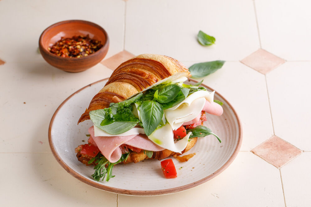 Croissant with ham, cheese and pesto sauce