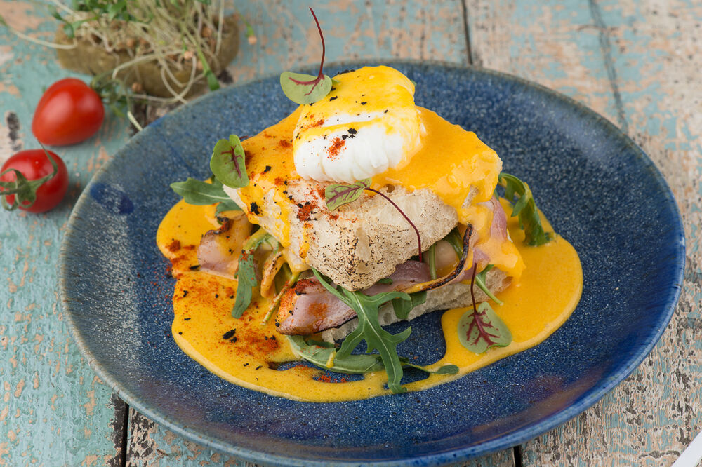 Egg Benedict with fried bacon and champignons
