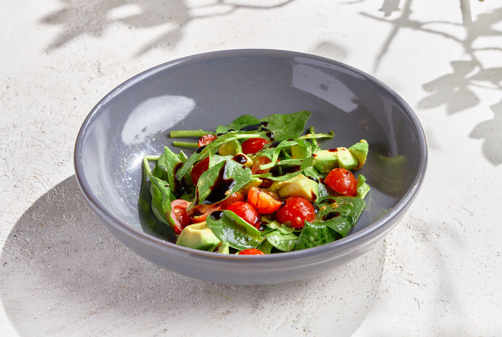 Young spinach with cherry tomatoes and avocado