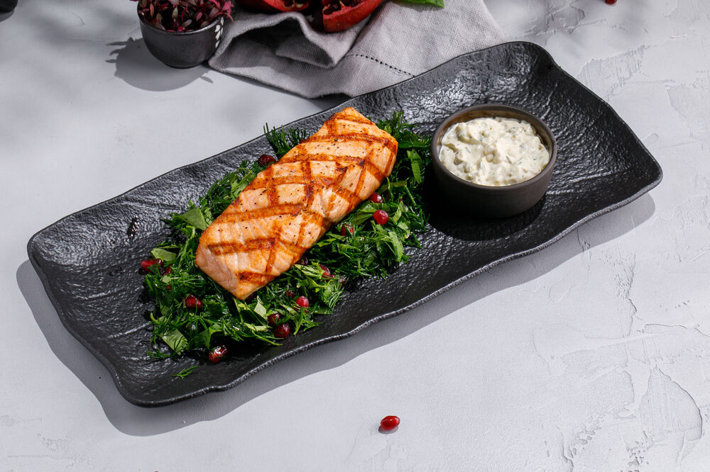 Salmon on a bed of aromatic grilled greens