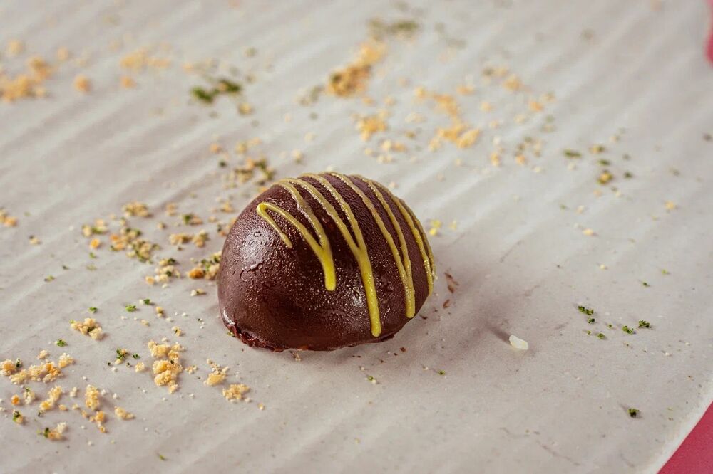 Candy with white chocolate and mango-passion fruit in dark glaze