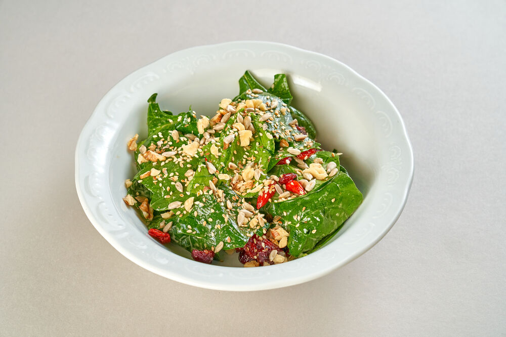 Salad with spinach, nut sauce, cranberries and goji berries