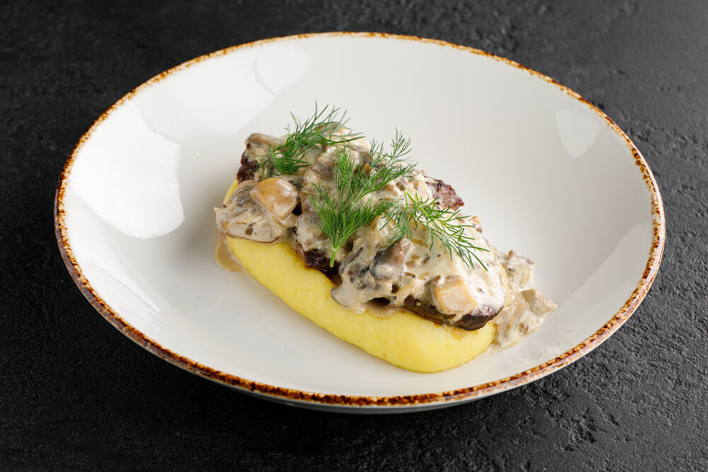 Veal with mashed potatoes and white taiga mushroom sauce