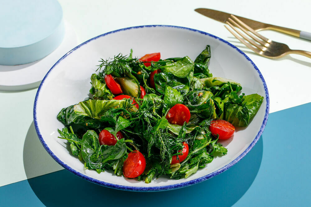 Fried fresh herbs with tomatoes