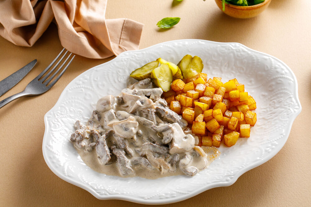 Beef Stroganoff with fried potatoes and pickles