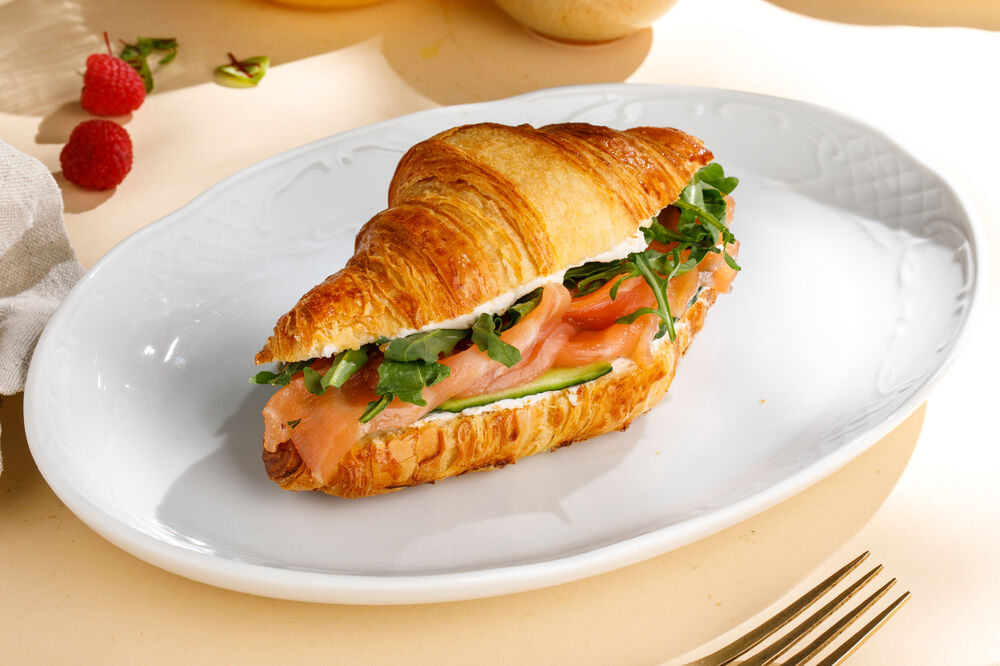 Croissant with salmon chef salting