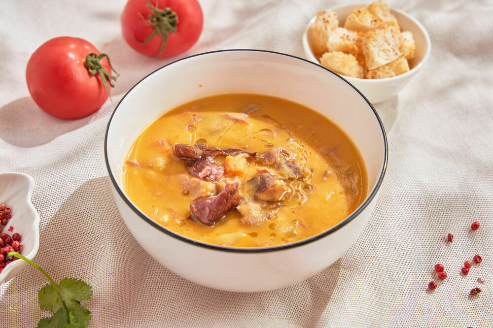 Pea soup with smoked meats and croutons