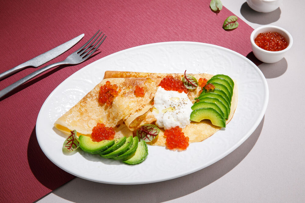 Pancakes with red caviar and avocado
