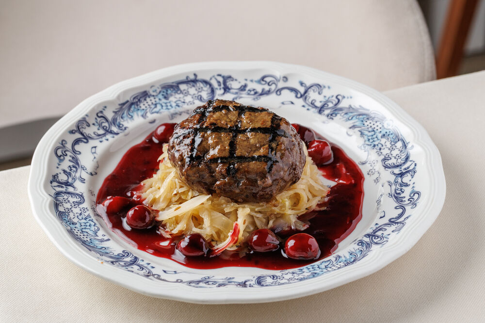 Venison steak with garden cherries and stewed cabbage