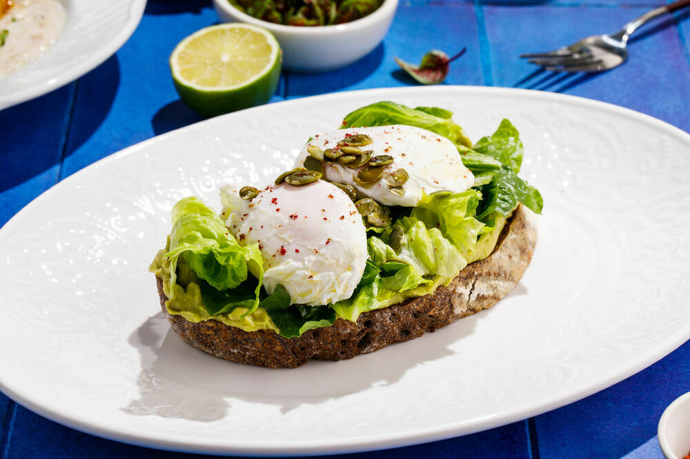 Green toast with avocado and poached eggs