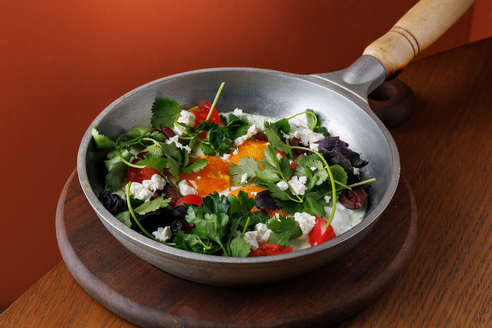 Fried eggs with tomatoes, olives and feta