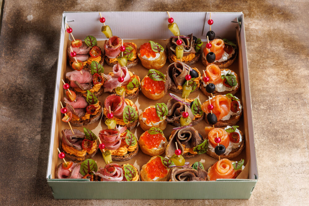A box of snacks with caviar profiteroles