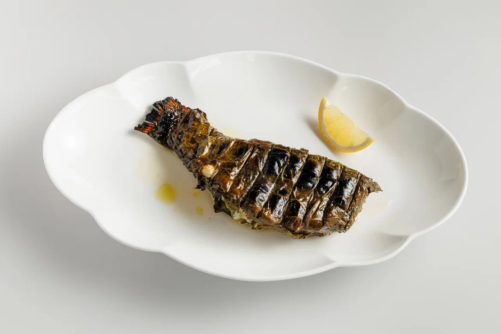 Fish in grape leaf on charcoal