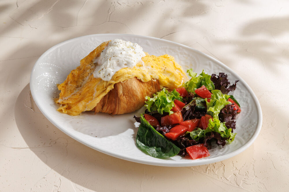 Croissant with stracciatella, spinach, tomatoes, egg, and basil.