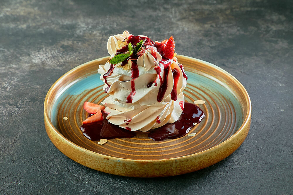 Meringue with butter cream and berry sauce