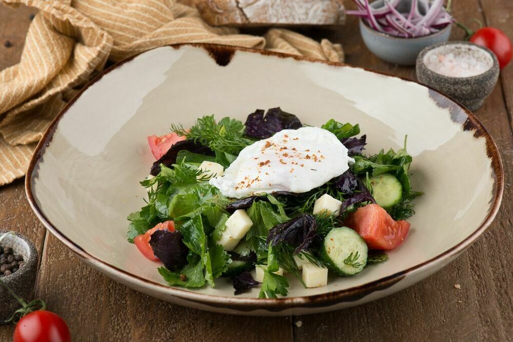 Salad with fragrant herbs and poached egg