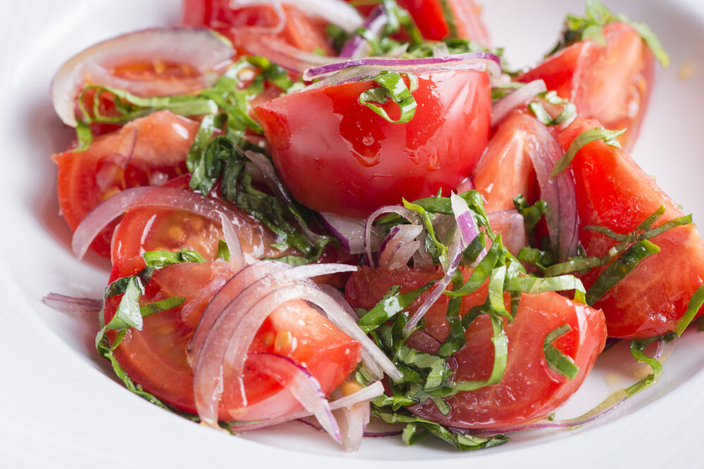 Salad with sweet ripe tomatoes, red onions and basil on promotion